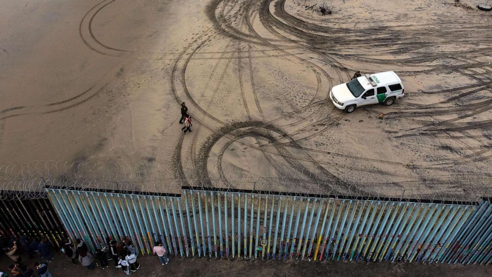 PHOTO: An aerial view of migrants who form part of the Central American migrant caravan being detained and escorted by a border patrol agent after crossing the U.S.-Mexico border fence in Playas de Tijuana, Baja California state, Mexico, Dec. 9, 2018.