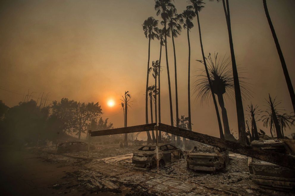 Smoke rises behind a leveled apartment complex as a wildfire burns in Ventura, Calif., Dec. 5, 2017. Over 100 structures have burned so far in Ventura County, officials said.