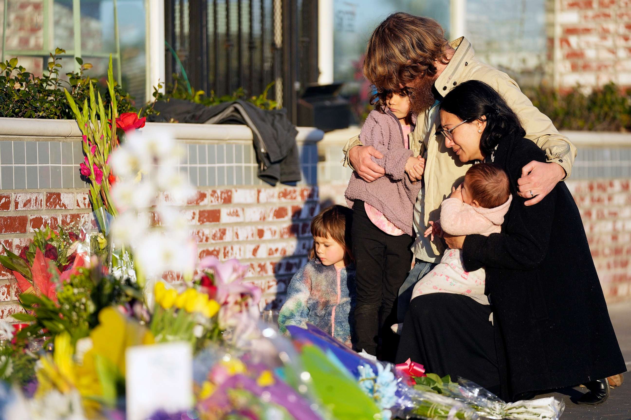 PHOTO: After a mass shooting, a family gathers at a memorial outside the Star Ballroom Dance Studio, Jan. 24, 2023, in Monterey Park, Calif.