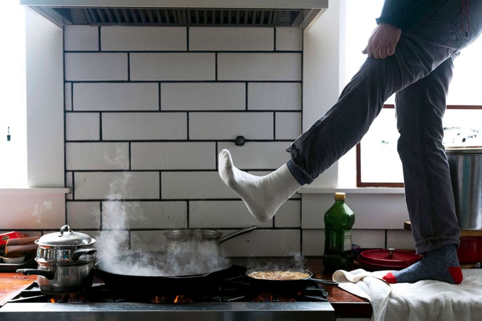 PHOTO: Jorge Sanhueza-Lyon stands on his kitchen counter to warm his feet over his gas stove on Feb. 16, 2021, in Austin, Texas. Power was out for thousands of Texans after temperatures dropped due to the snow storm hitting the area on Sunday night. 