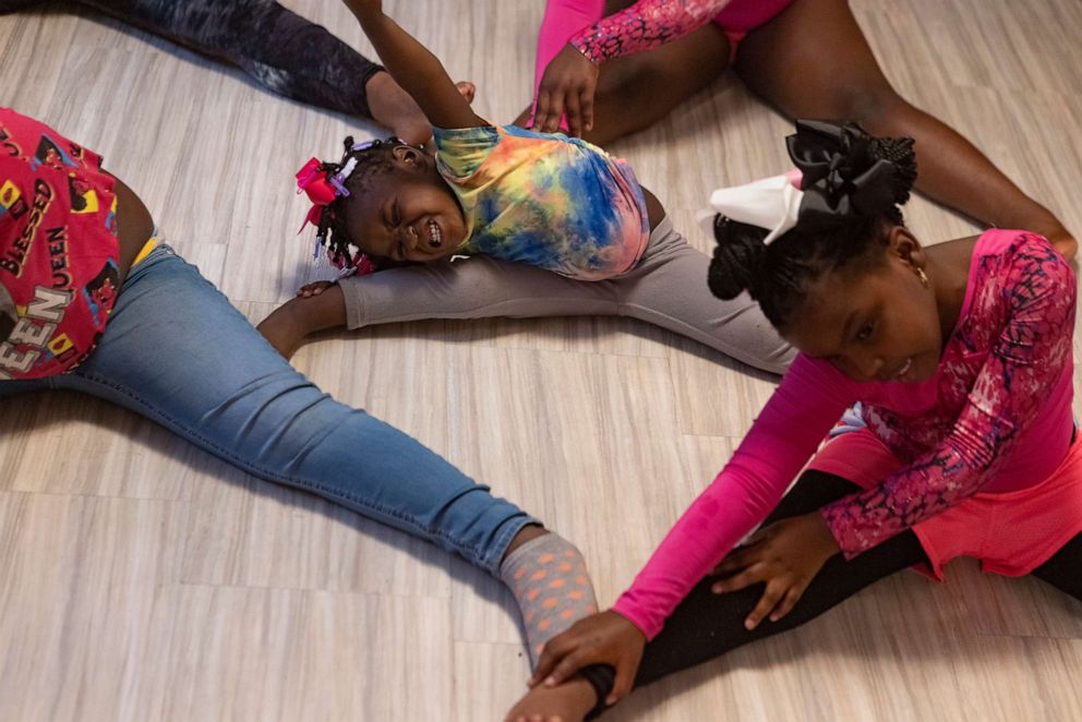 PHOTO: Tykirel Jordan's daughter Alaysia, center, stretches with other girls in DaRealBarbSquad, a dance group Jordan coaches for children whose parents are in the Youth Towers program, Oct. 28, 2021, in Birmingham, Ala.
