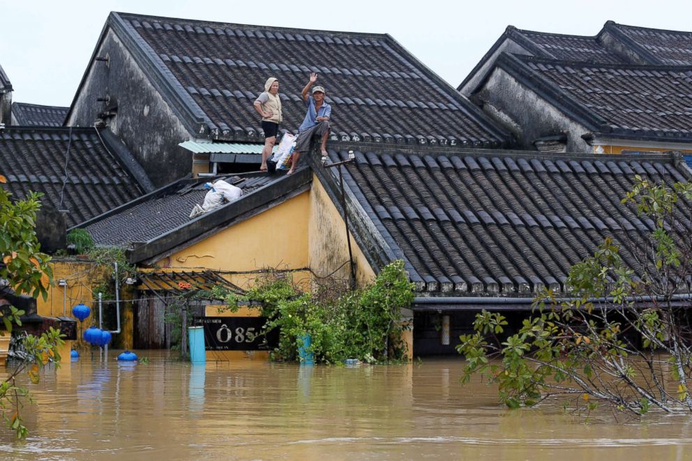 PHOTO: People stand on the roof of their house along a submerged street in the UNESCO heritage ancient town of Hoi An after typhoon Damrey hit Vietnam, Nov. 6, 2017.