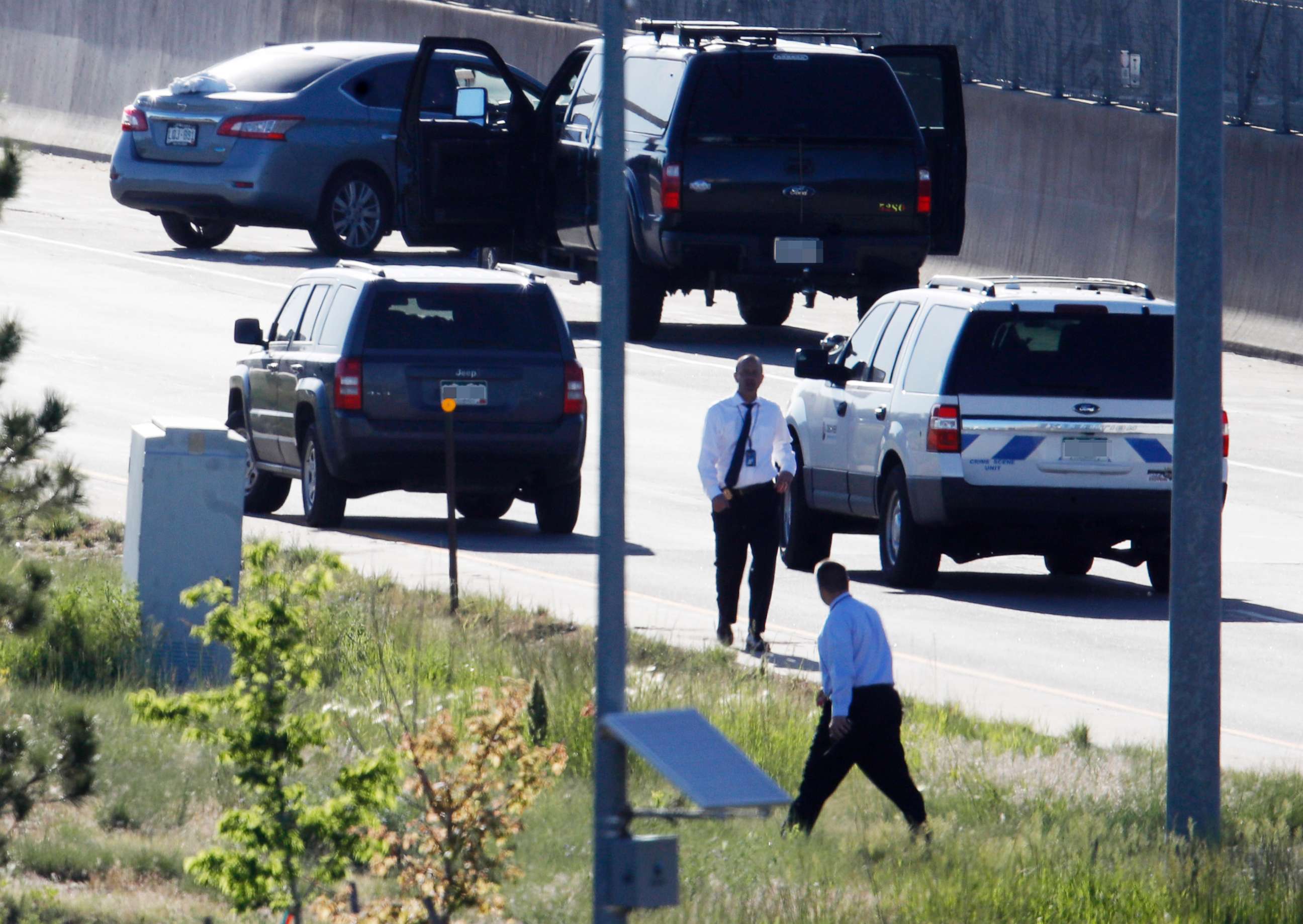 PHOTO: Denver Police Department detectives, investigate near where a Nissan sedan, top left, being driven by an Uber driver crashed into a retaining wall along Interstate 25 south of downtown Denver, June 1, 2018.