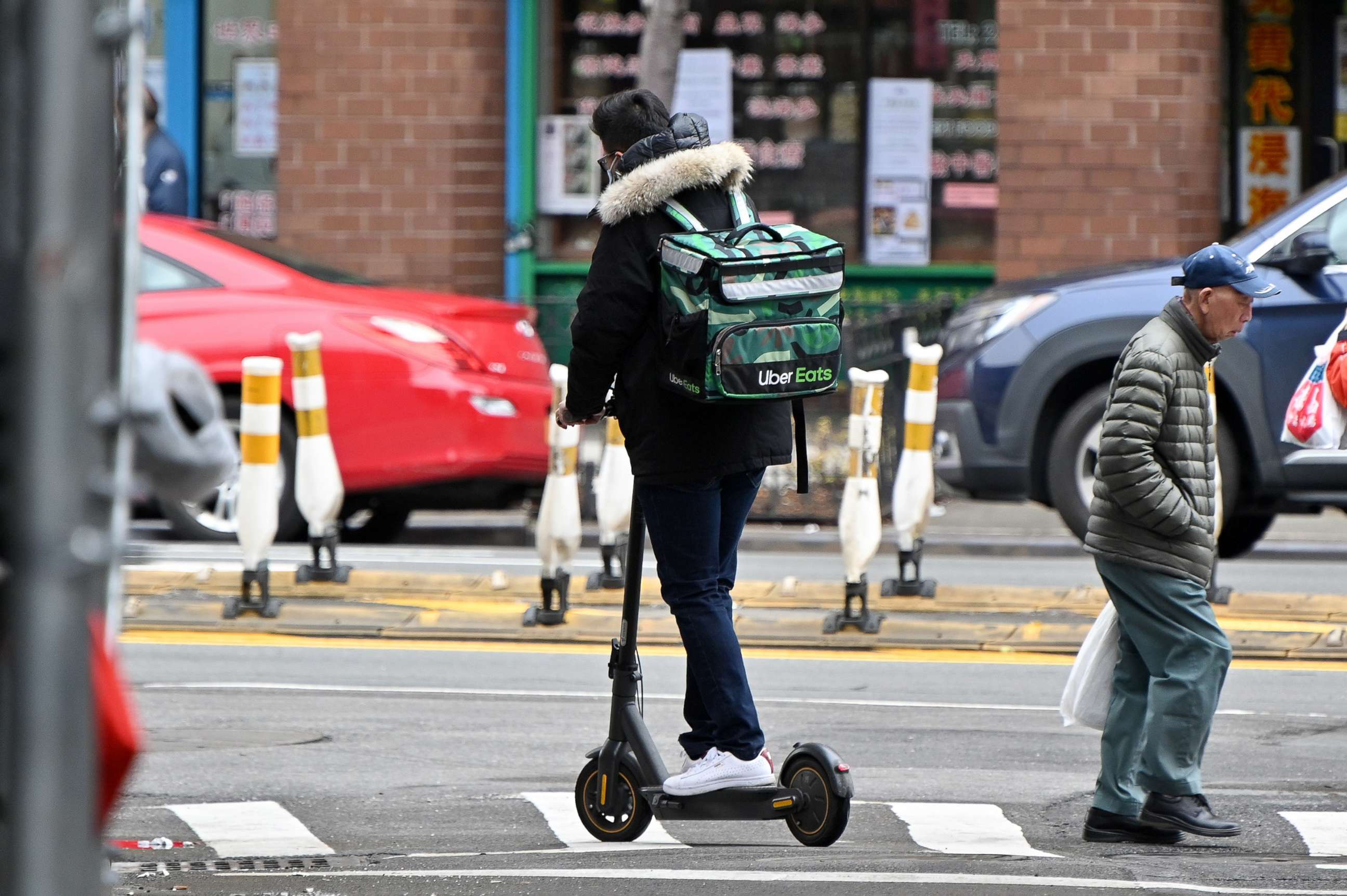 PHOTO: An Uber Eats delivery worker is seen riding an electric scooter in Manhattan's Chinatown on March 19, 2020 in New York City. 