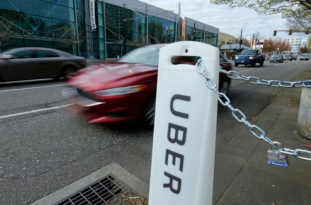 PHOTO: An Uber sign points to drop off and pick up location on a city street in Portland, March 19, 2016.