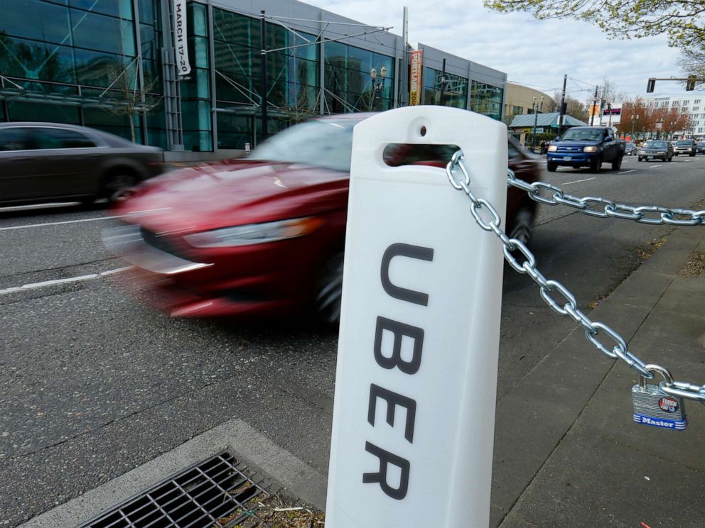 PHOTO: An Uber sign points to drop off and pick up location on a city street in Portland, March 19, 2016.
