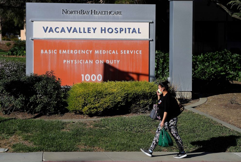 PHOTO: A woman wears a surgical mask as she walks by the VacaValley Hospital, on Feb. 27, 2020, in Vacaville, Calif. A Solano County, California resident, who is the first confirmed case of CO