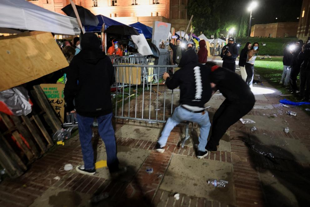 PHOTO: Counter-protesters attempt to move a barricade amidst clashes with protesters in support of Palestinians in Gaza at an encampment on the campus of the University of California Los Angeles on May 1, 2024. 