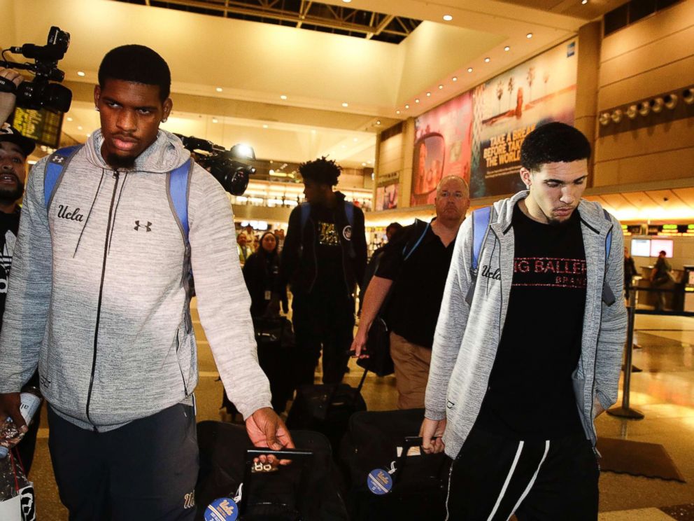 PHOTO: UCLA basketball players Cody Riley, left, LiAngelo Ball, right, and Jalen Hill, background center, are surrounded by the media as they leave the Los Angeles International Airport, Nov. 14, 2017, in Los Angeles.