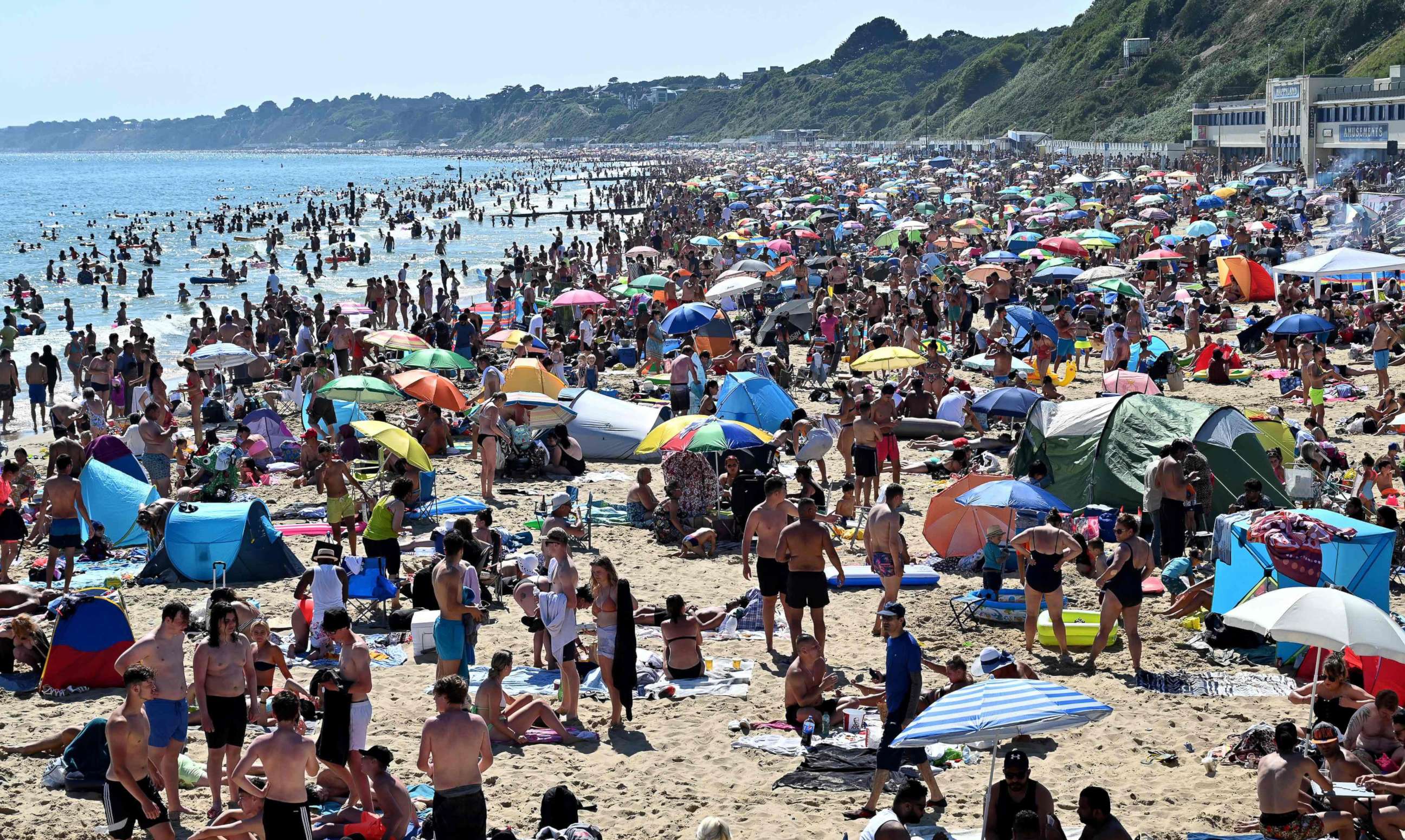 PHOTO: Beachgoers enjoy the sunshine as they sunbathe and play in the sea on Bournemouth beach in Bournemouth, southern England, on June 25, 2020.