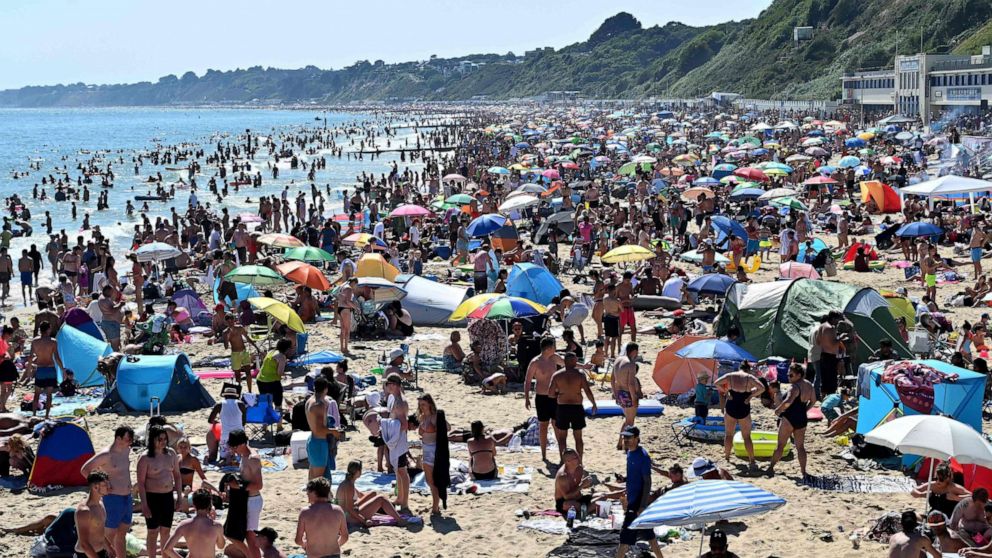 PHOTO: Beachgoers enjoy the sunshine as they sunbathe and play in the sea on Bournemouth beach in Bournemouth, southern England, on June 25, 2020.