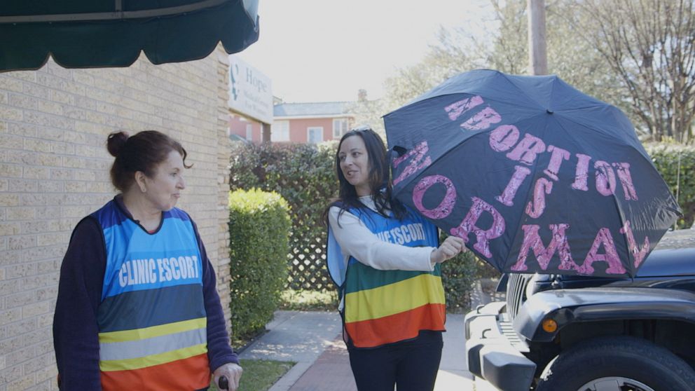 PHOTO: Clinic escort Kathryn Simpson was inspired to put the phrase on her umbrella for protesters to see while she shields patients.