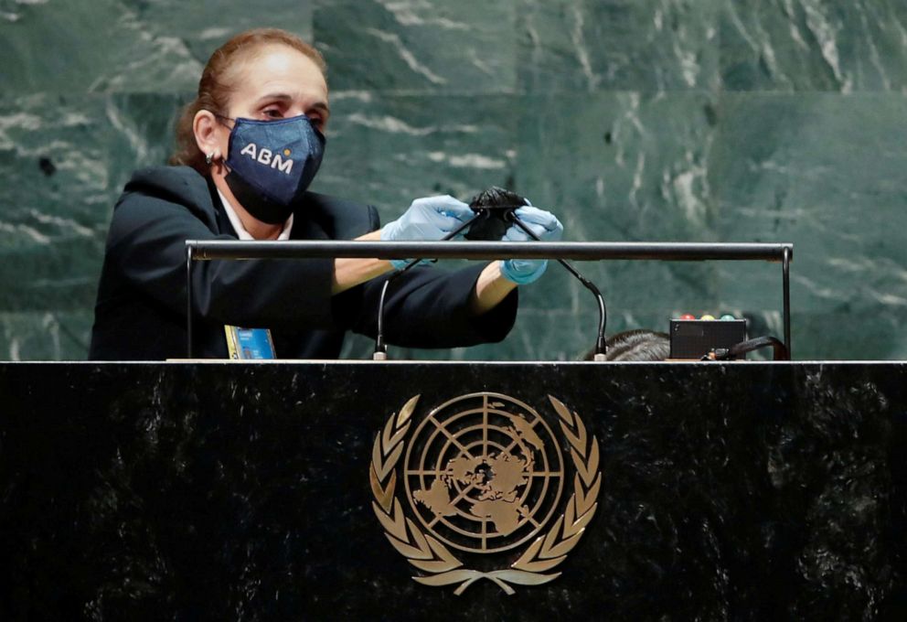 PHOTO: A United Nations employee cleans the microphones at the podium after Brazil's President Jair Bolsonaro spoke and before President Joe Biden's address during the 76th Session of the U.N. General Assembly in New York City, Sept. 21, 2021.