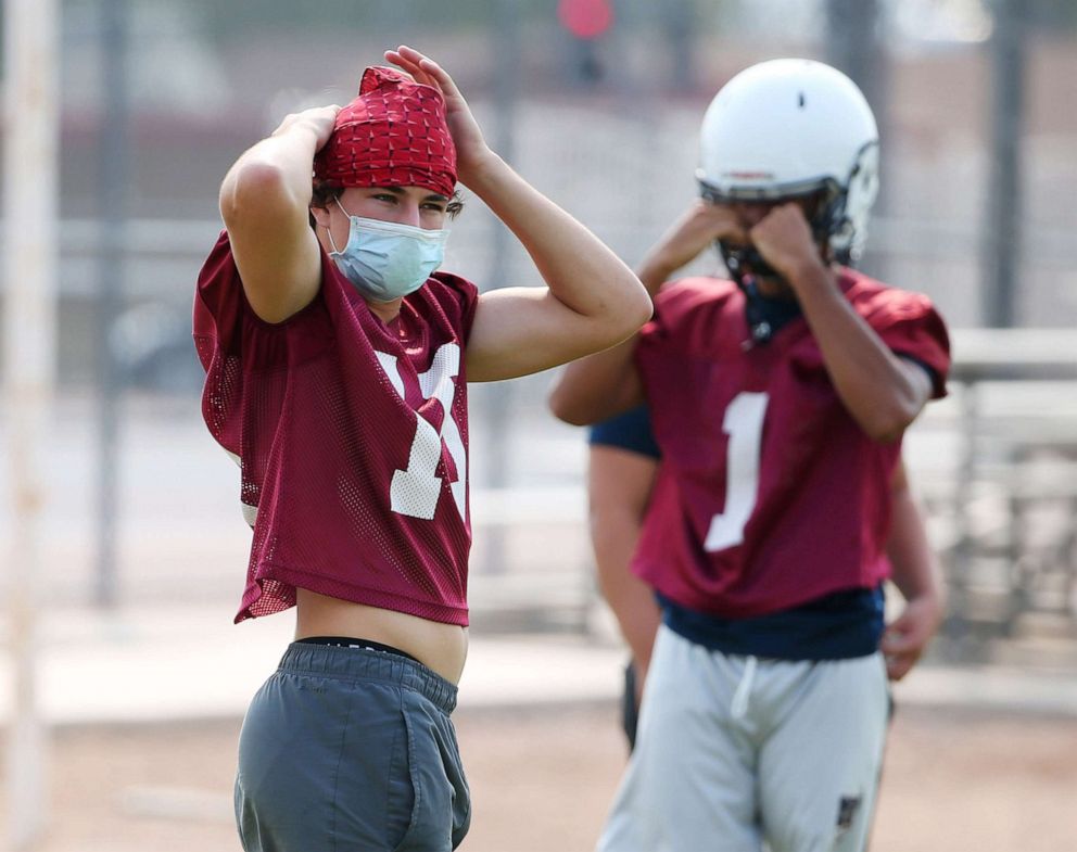PHOTO: McClintock High students prepare for football practice in Tempe, Ariz., Sept. 8, 2020. Tempe Union High School District mandates players wear masks to protect against CODID-19.