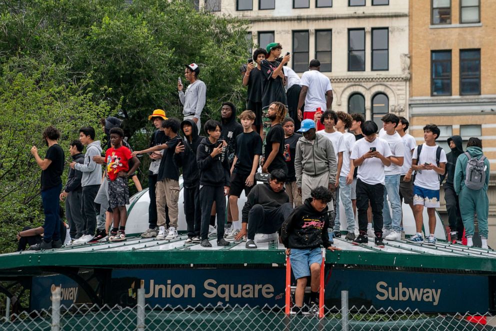 PHOTO: People stand on top of a subway station entrance after popular live streamer Kai Cenat announced a "giveaway" event at Union Square in New York City, Aug. 4, 2023.
