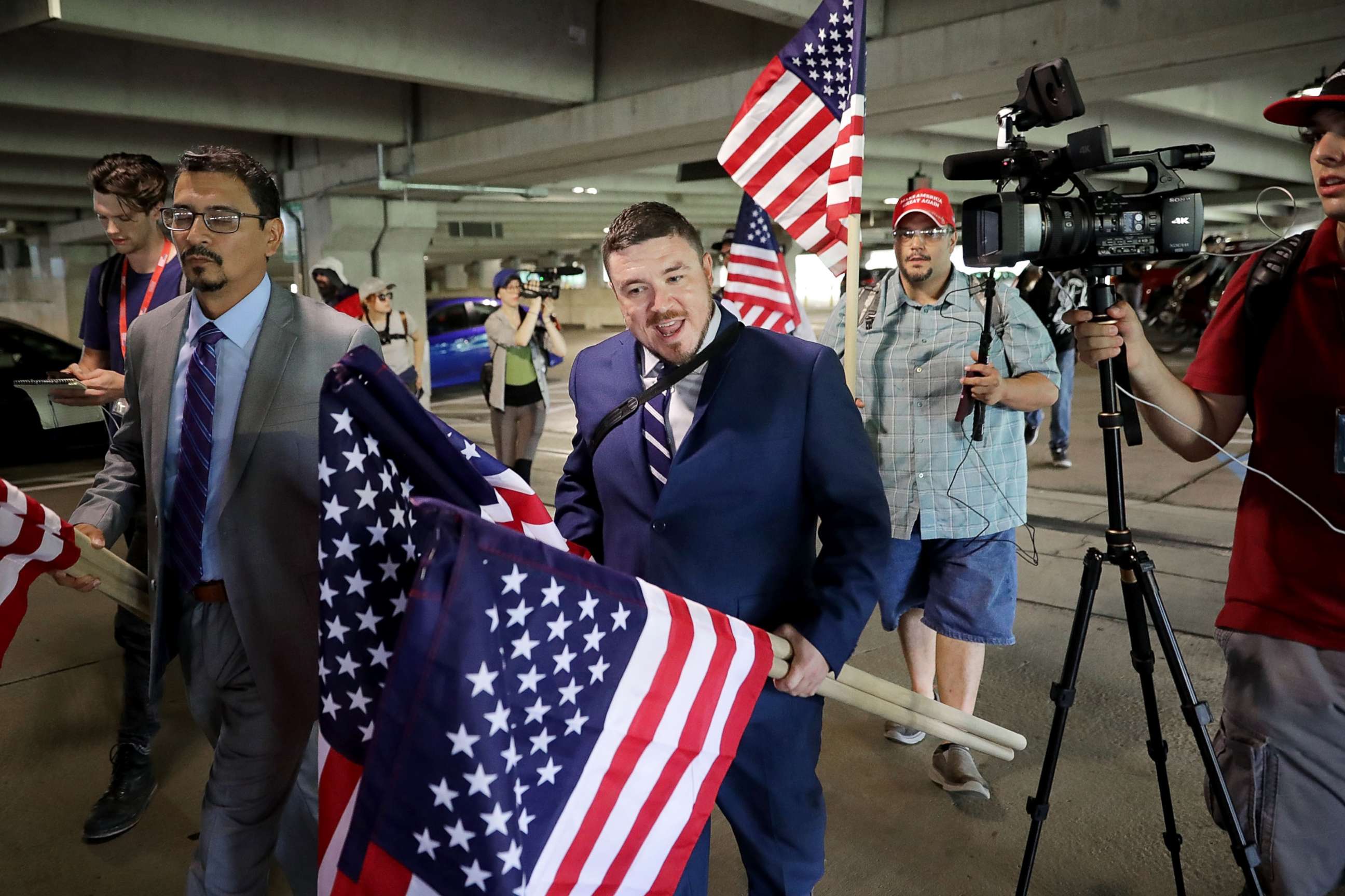 PHOTO: Surrounded by his supporters, reporters, and Fairfax County Police, Jason Kessler walks toward the Vienna/Fairfax GMU Metro Station to travel to the White House for his "Unite the Right" rally, Aug. 12, 2018, in Vienna, Virginia.