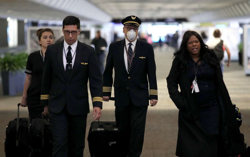 PHOTO: A United Airlines flight crew walks through the terminal at San Francisco International Airport on April 12, 2020, in San Francisco.