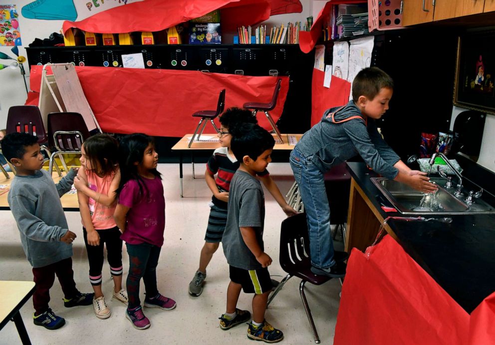 PHOTO: Children line up to wash hands before lunch at a daycare held at Martinez Elementary School in Abilene, Texas Wednesday April 1, 2020. The child care is organized by United Way of Abilene and is being provided at no cost for essential workers