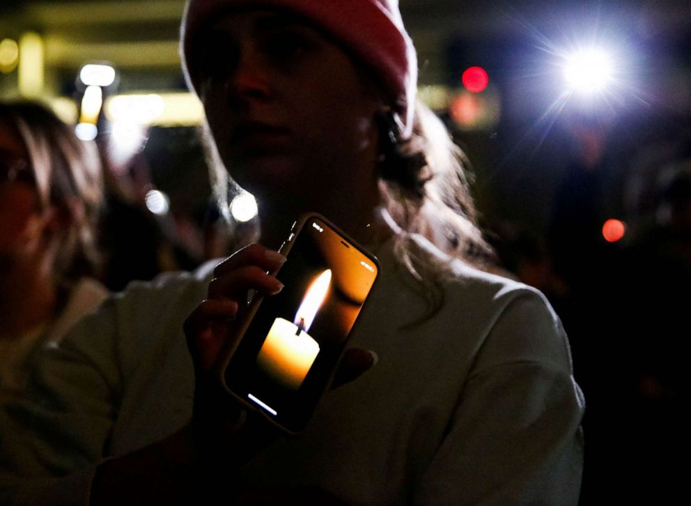 PHOTO: An attendee holds up a digital candle on her phone as a moment of silence is taken for the victims during a vigil at the University of Idaho for four students found dead in their residence, Nov. 13 in Moscow, Idaho, Nov. 30, 2022.