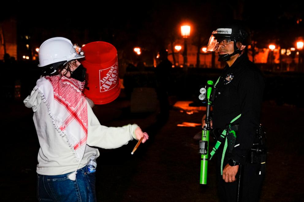 PHOTO: A person protests in front of a police officer after police arrived on the campus at the University of Southern California to clear an encampment set up by pro-Palestinian demonstrators, May 5, 2024, in Los Angeles.