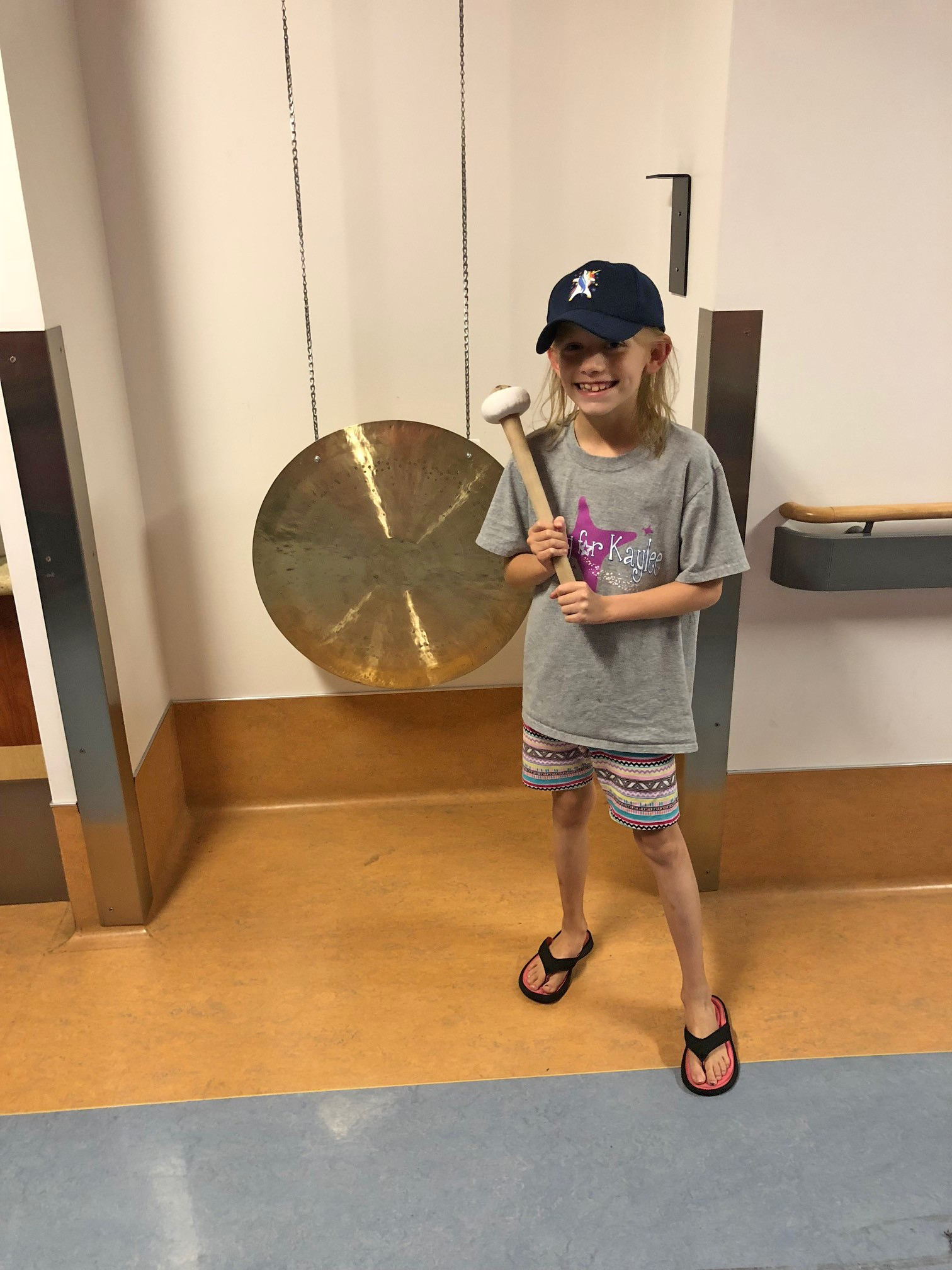 PHOTO: Kaylee Kruise stands in front of the gong at UPMC Children's Hospital of Pittsburgh.