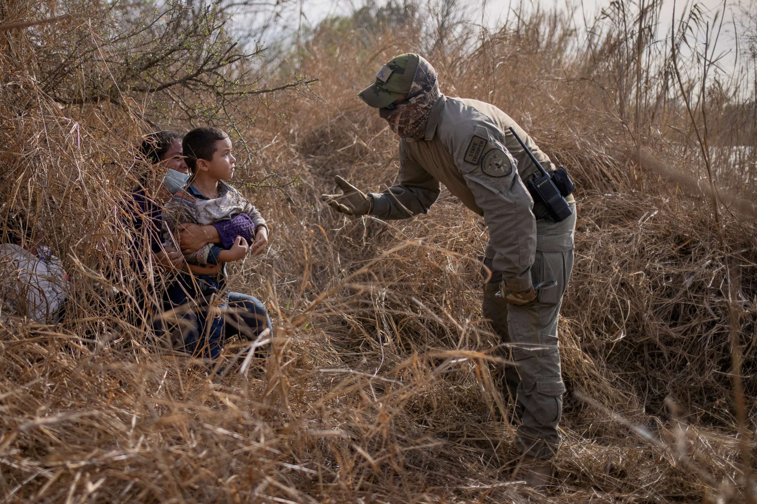 FILE PHOTO: A Texas State Trooper asks asylum seeking migrants Edith and her son Harbin Ordonez, 4, to come out of hiding after the Honduran nationals crossed the Rio Grande river into the United States from Mexico on March 9, 2021.