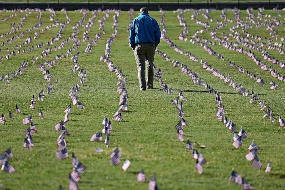 PHOTO: Chris Duncan, whose 75 year old mother Constance died from COVID-19 on her birthday, walks through a COVID Memorial Project installation of 20,000 American flags on the National Mall, Sept. 22, 2020, in Washington, D.C.