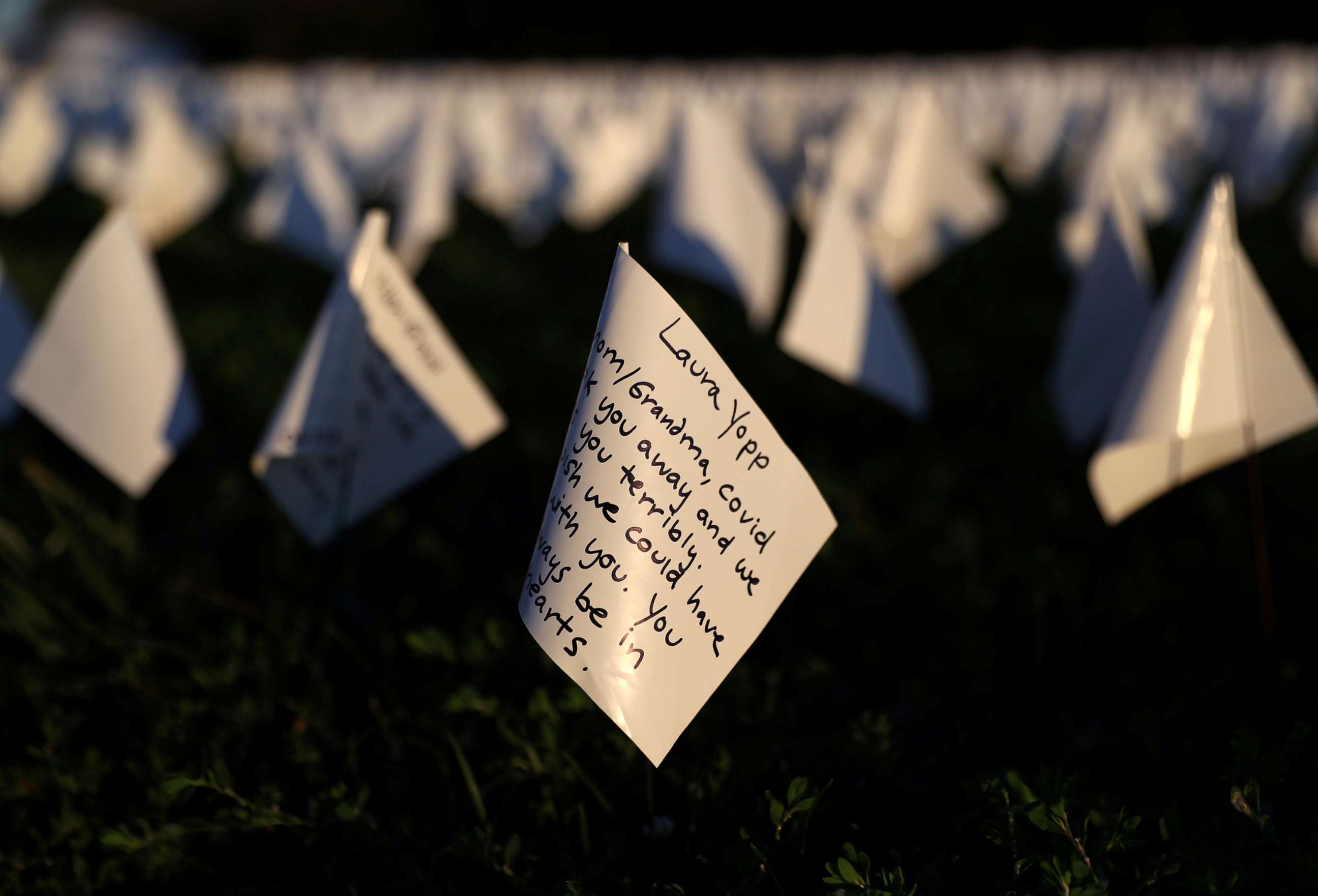 PHOTO: Notes to loved ones who died due to COVID-19, are written on white flags as part of a memorial for Americans as the national death toll reached 700,000, next to the Washington Monument in Washington, D.C., Oct. 1, 2021.