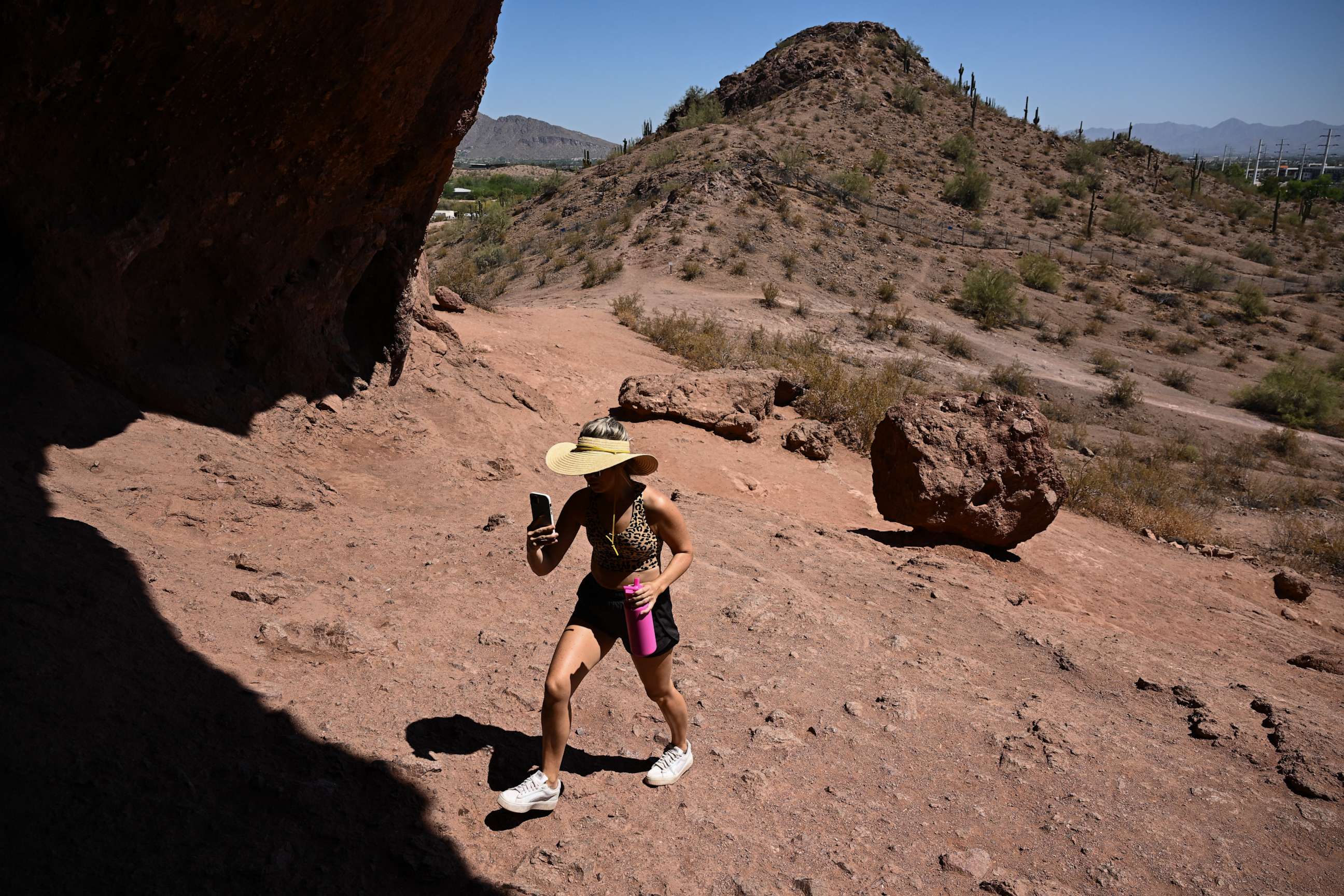 PHOTO: A visitor from Canada carries water while hiking up the Hole In The Rock trail during a record heat wave in Phoenix, Arizona, on July 19, 2023.