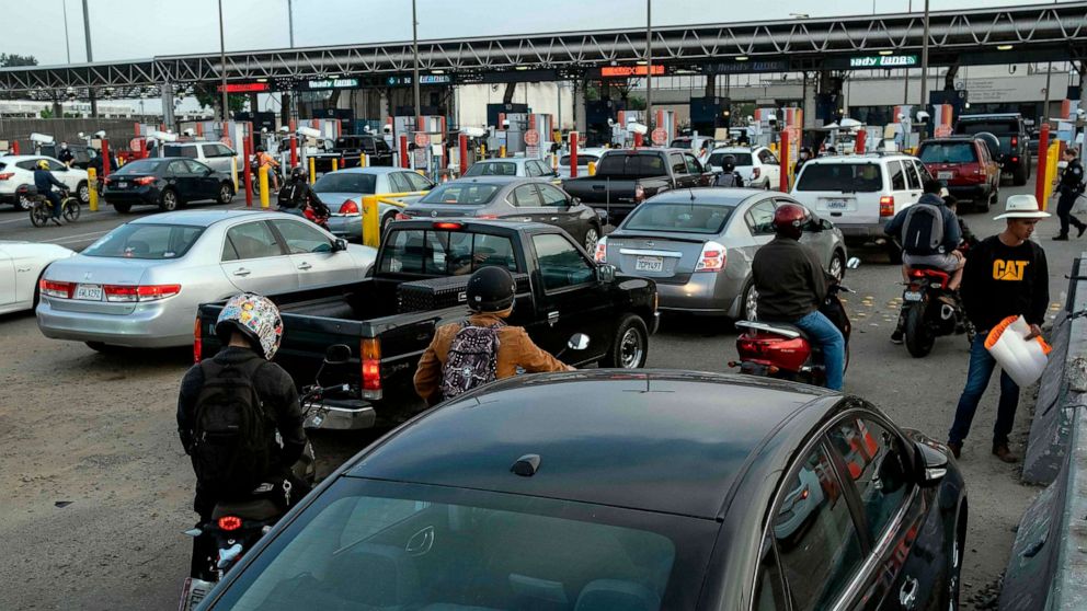 PHOTO: Commuters queue to cross Mexican border towards the US at the Otay commercial crossing port in Tijuana, Baja California state, Mexico, on July 7, 2020.