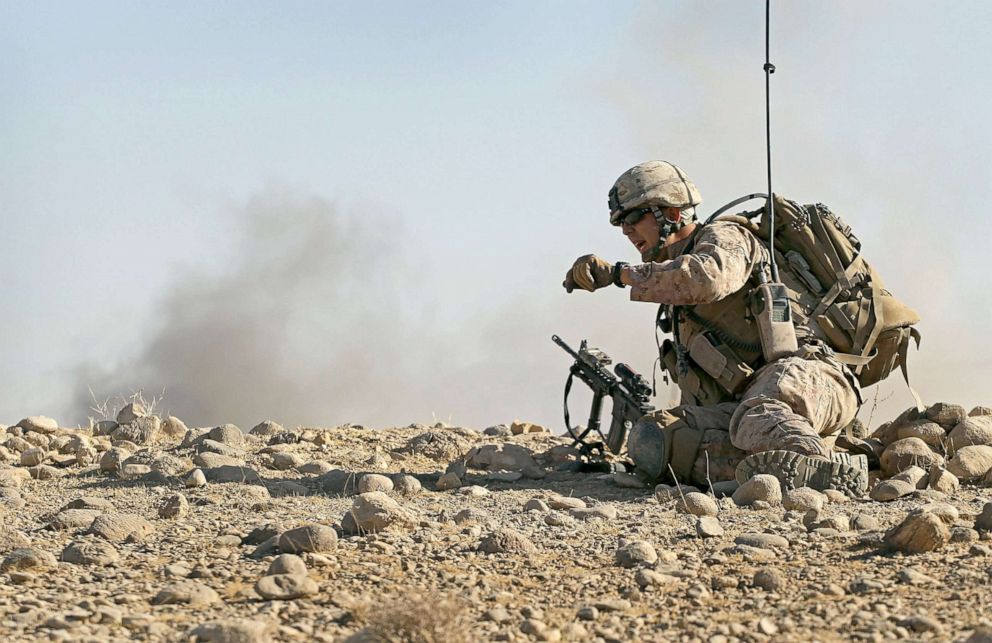 PHOTO: U.S. Marine attached to India Battery, 3rd Battalion  watches dust and smoke fly as an artillery round is fired onto an enemy position during a firefight near Forward Operating Base (FOB) Zeebrugge, Oct. 9, 2010, near Kajaki, Afghanistan.