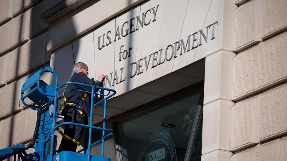 PHOTO: A worker removes the U.S. Agency for International Development sign on their headquarters on Feb. 7, 2025 in Washington.