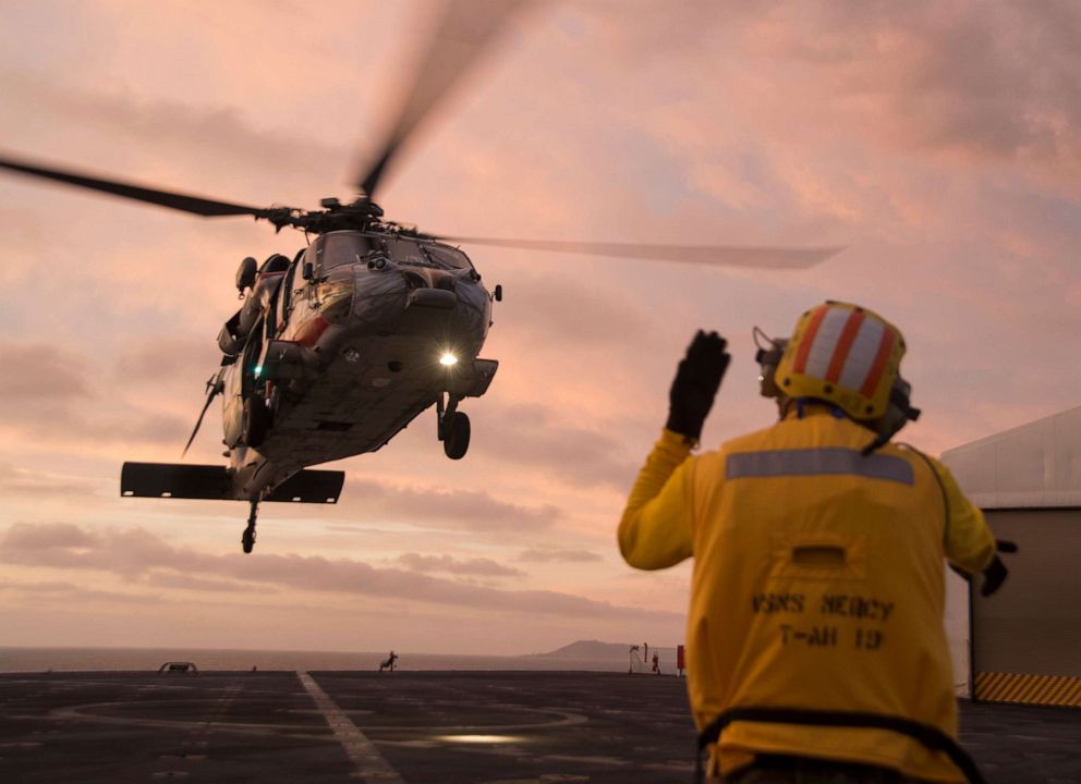PHOTO: Aviation Boatswain's Mate 2nd Class Edwin Macaraeg, signals to a Sea Hawk helicopter to land on the flight deck of the hospital ship USNS Mercy, Sept. 25, 2019.