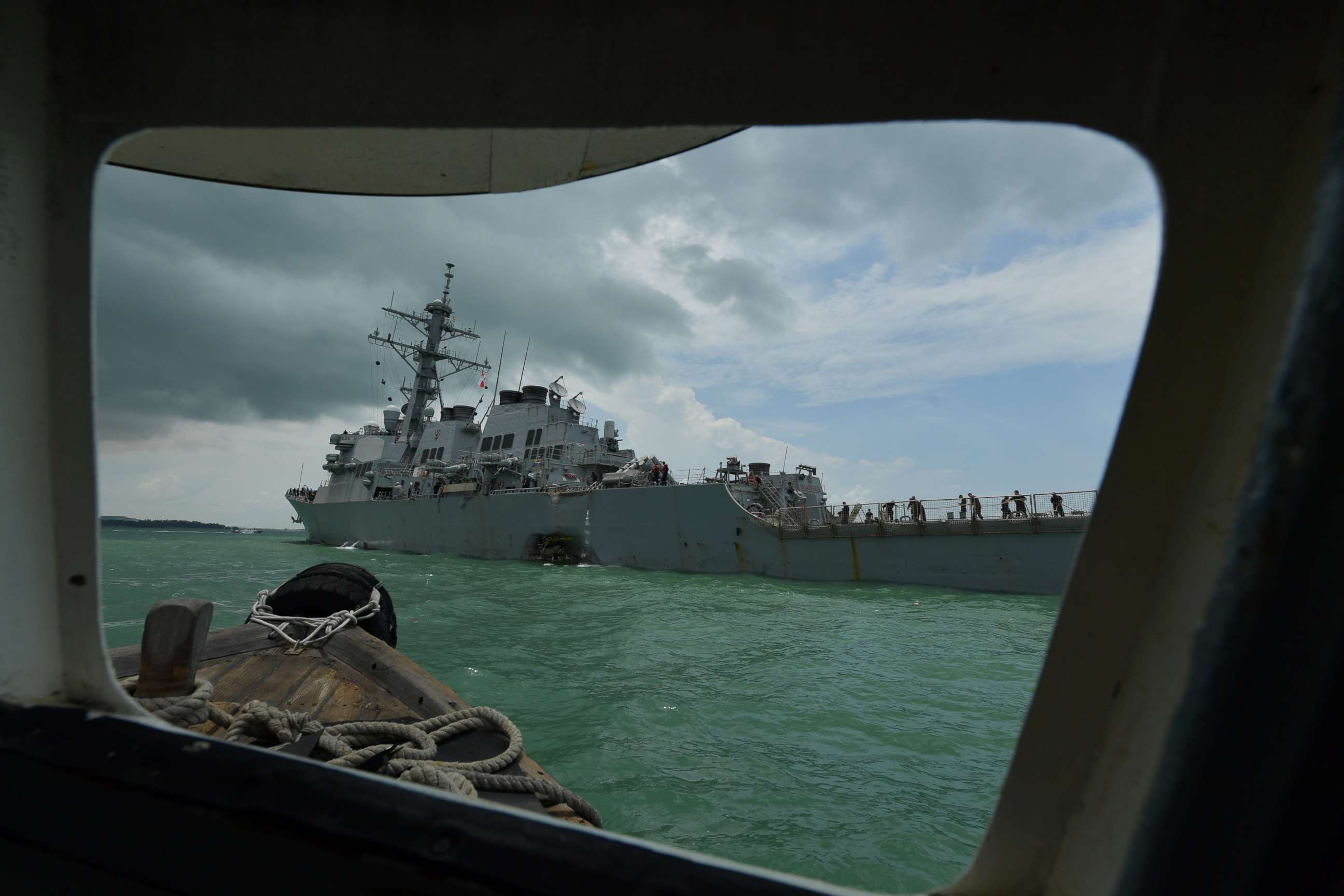 PHOTO: Pictured through a window frame, the U.S. Navy missile destroyer USS John S. McCain is towed into the Changi Navy Base off the eastern coast of Singapore, Aug. 21, 2017. 