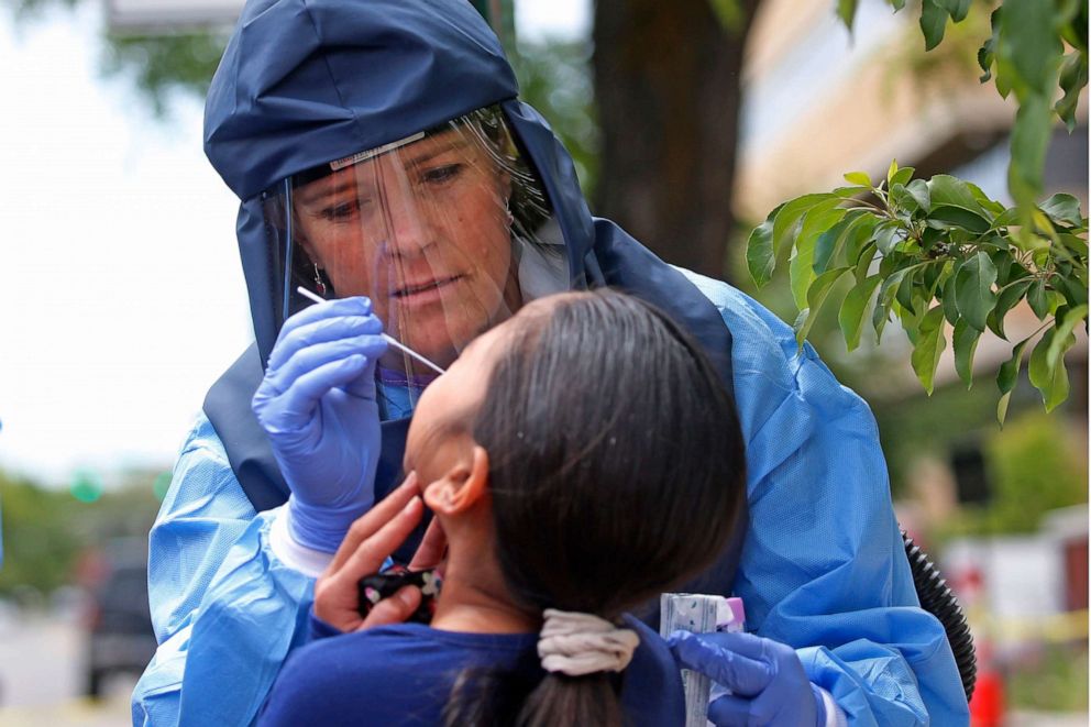 PHOTO: Salt Lake County Health Department public health nurse Lee Cherie Booth performs a COVID-19 test outside the department in Salt Lake City, May 14, 2020.
