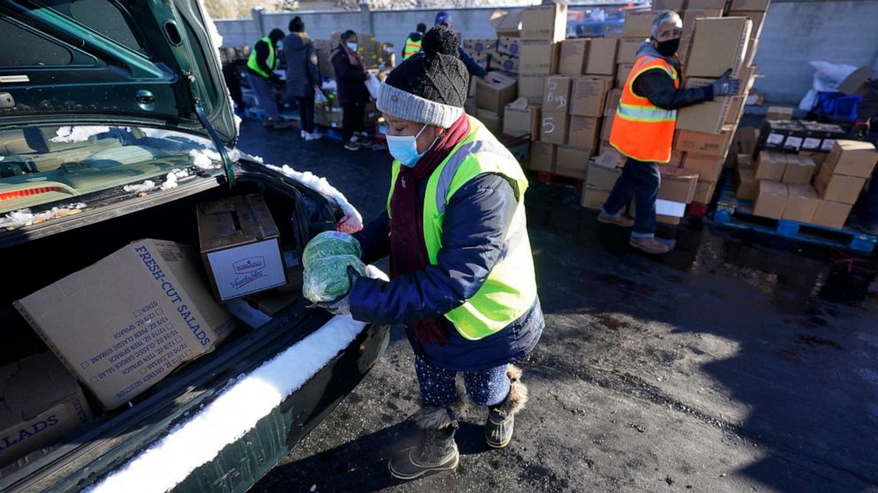 PHOTO: Volunteers wear masks as they load food in to cars at the Utah Food Bank's mobile food pantry, Nov. 12, 2020, in West Valley City, Utah.
