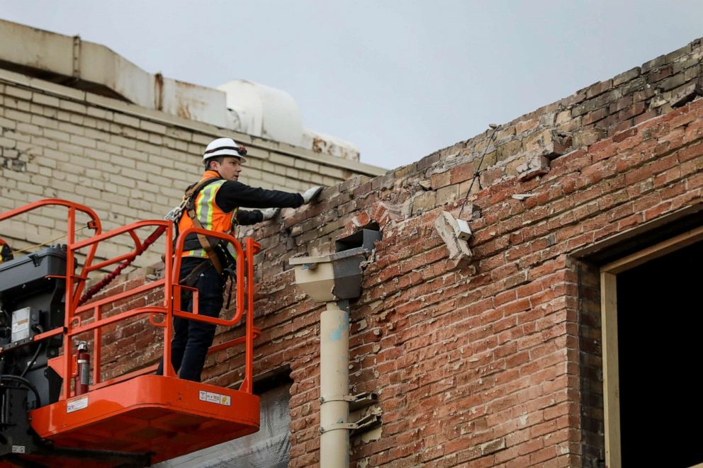 PHOTO: A worker checks the brick facade of a building in Salt Lake City after an earthquake on Wednesday, March 18, 2020.