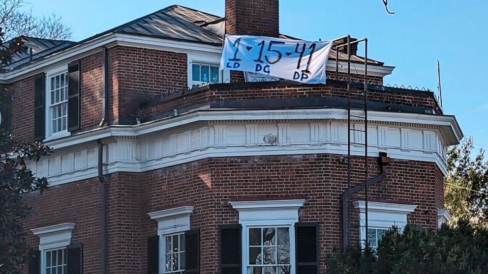 PHOTO: A banner with the numbers and initials of three University of Virginia football players, Lavel Davis Jr., Devin Chandler and D'Sean Perry, who were killed in a shooting hangs from a home near the crime scene, Nov. 14, 2022, in Charlottesville.