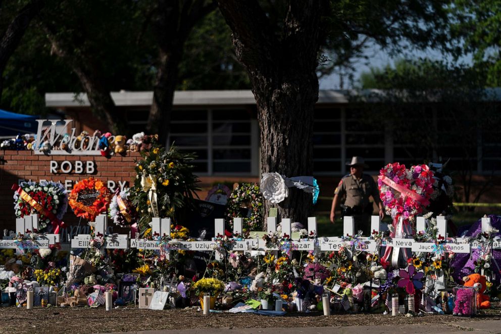 PHOTO: In this May 28, 2022, file photo, flowers and candles are placed around crosses at a memorial outside Robb Elementary School in Uvalde, Texas, to honor the victims killed in the school shooting.