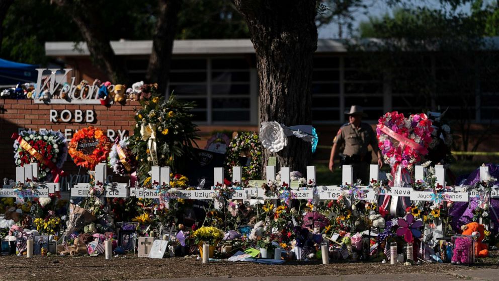 PHOTO: Flowers and candles are placed around crosses, May 28, 2022, at a memorial outside Robb Elementary School in Uvalde, Texas, to honor the victims killed in the school shooting a few days prior.