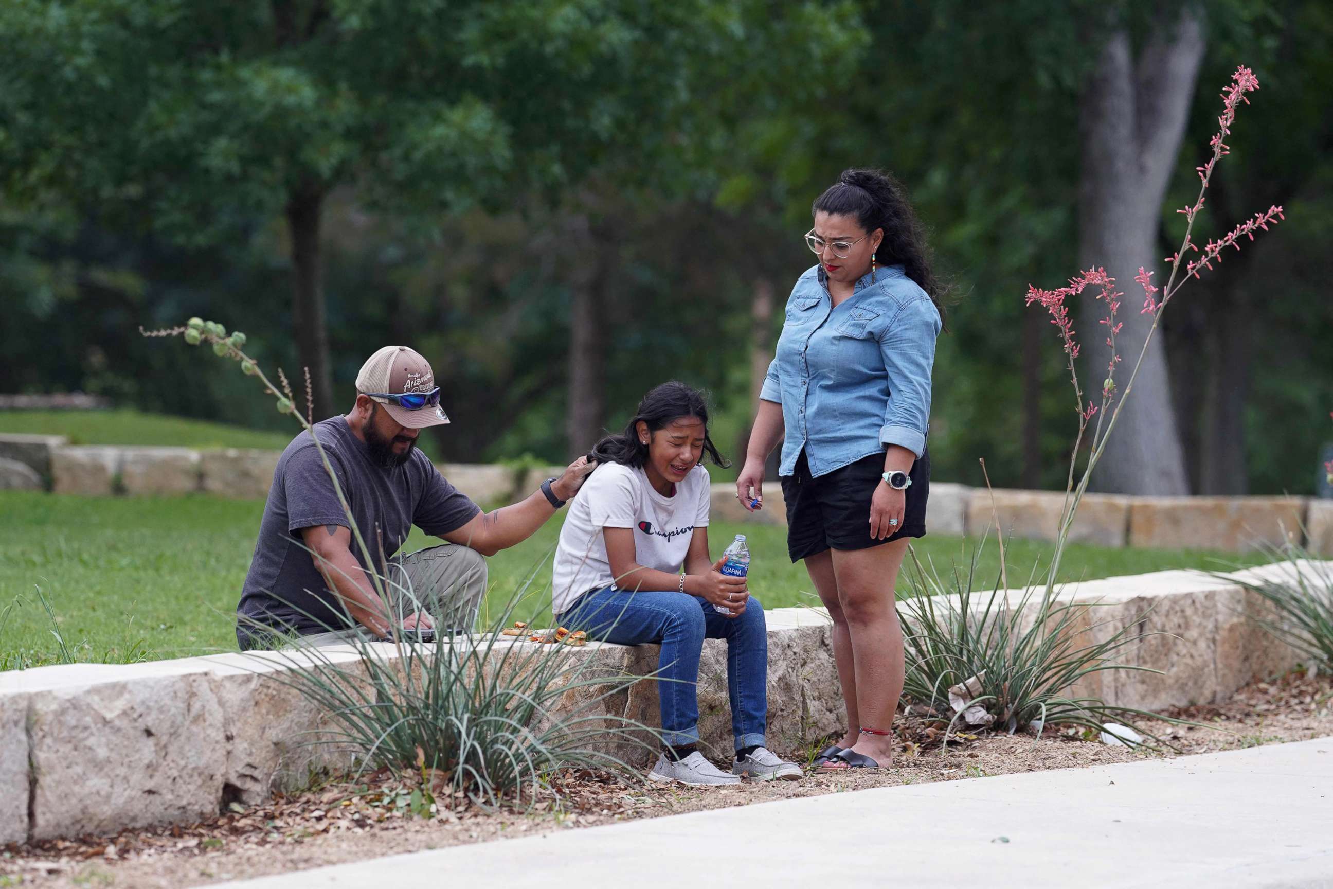 PHOTO: Adults comfort a girl crying outside the civic center in Uvalde, Texas, May 24, 2022, following a shooting at an elementary school.