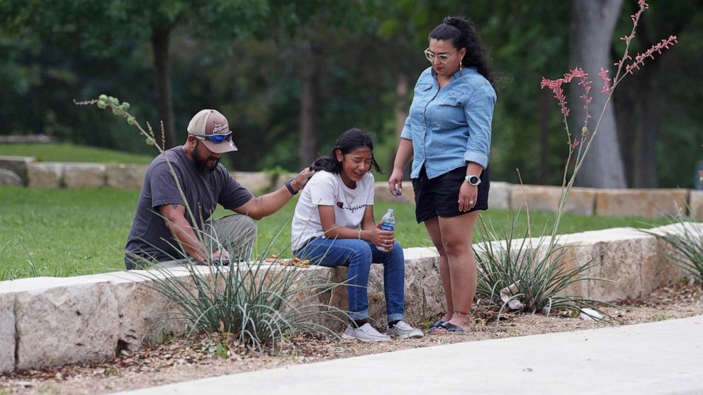 PHOTO: Adults comfort a girl crying outside the civic center in Uvalde, Texas, May 24, 2022, following a shooting at an elementary school.