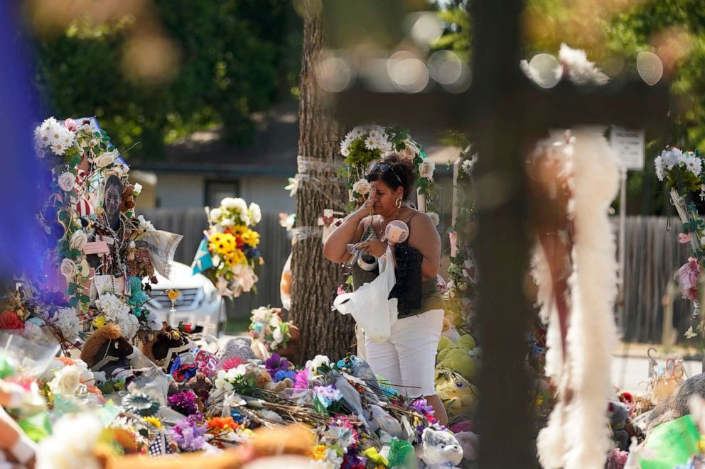 PHOTO: A mourner visits a memorial at Robb Elementary as the Texas Brown Berets prepare to march with family members of those killed and injured in the school shooting at Robb Elementary, Sunday, July 10, 2022, in Uvalde, Texas. 