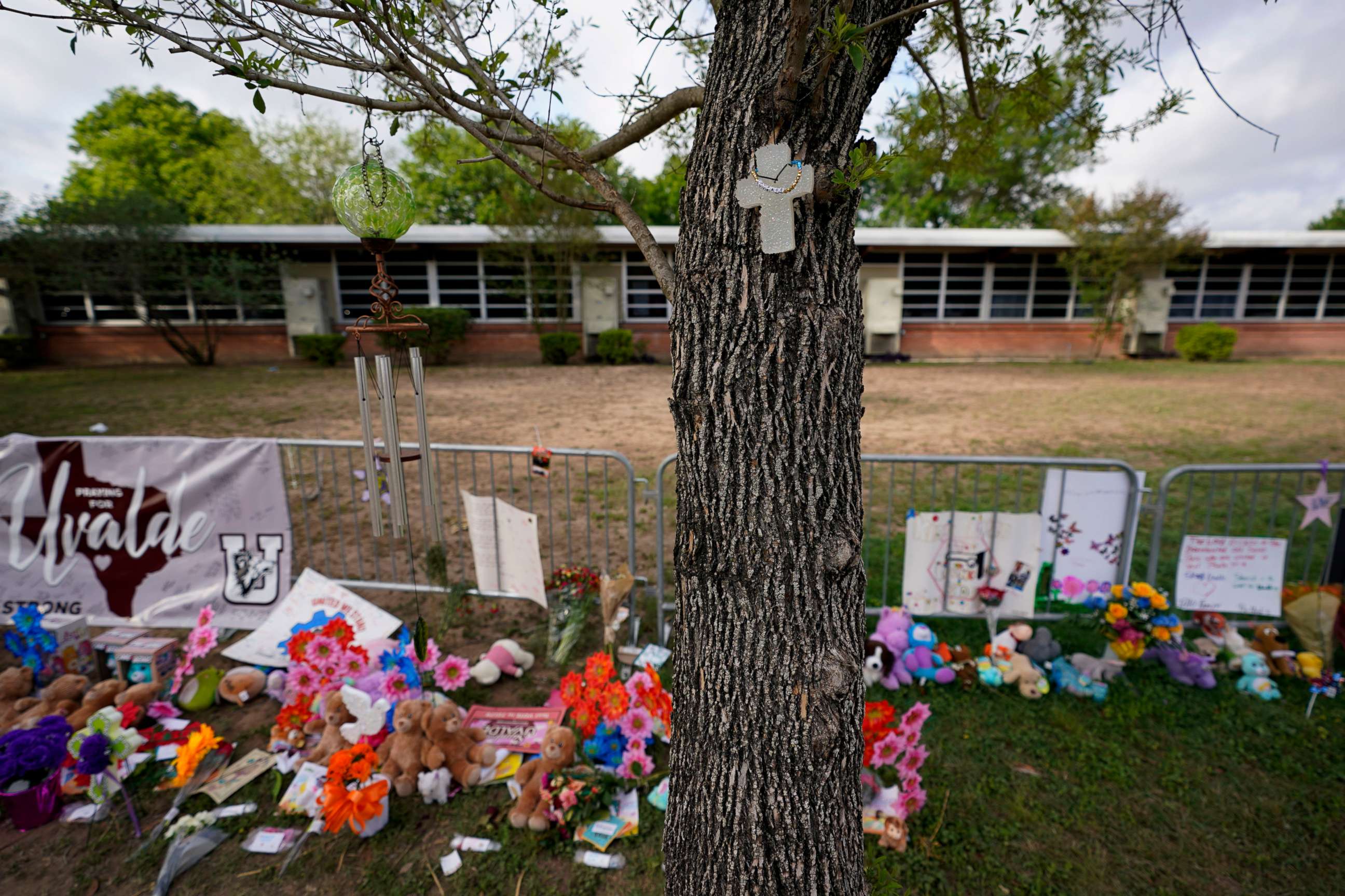 PHOTO: A cross hangs on a tree at Robb Elementary School where a memorial has been created to honor the victims killed in the recent school shooting, June 3, 2022, in Uvalde, Texas.