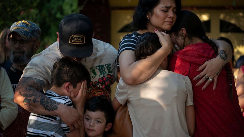 PHOTO: Raquel Martinez, comforts her two daughters while her husband, Daniel Martinez, comforts their sons outside Robb Elementary School, on May 26, 2022, in Uvalde, Texas.