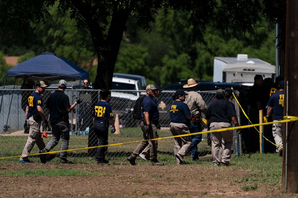 Photo: Investigators walk through a schoolyard at Robb Elementary School on May 25, 2022 in Uvalde, Texas.