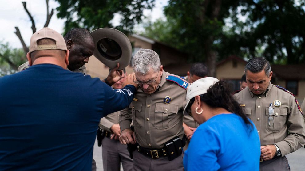 PHOTO: Texas Department of Public Safety Director Steven McCraw, center, prays with pastor Gabriel Davila and wife, Sylvia, outside Robb Elementary School in Uvalde, Texas, May 30, 2022.