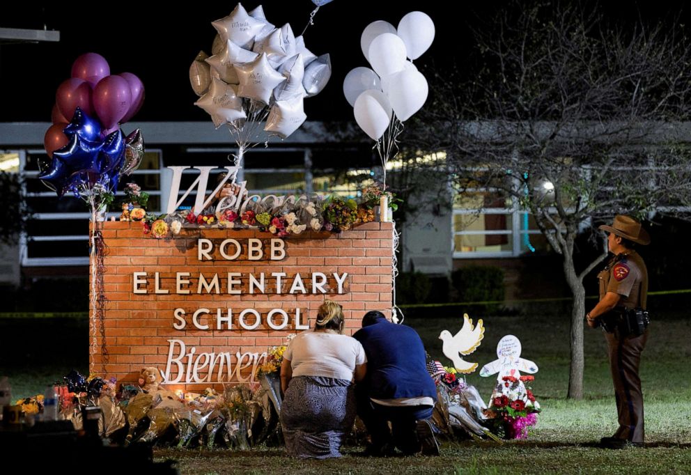 PHOTO: People pay their respects in this photo from May 25, 2022, at a makeshift memorial outside Robb Elementary School, the site of a mass shooting, in Uvalde, Texas.