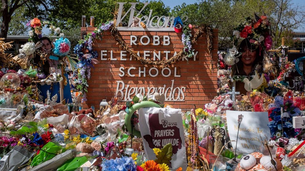 PHOTO: The Robb Elementary School sign is seen covered in flowers and gifts on June 17, 2022, in Uvalde, Texas.