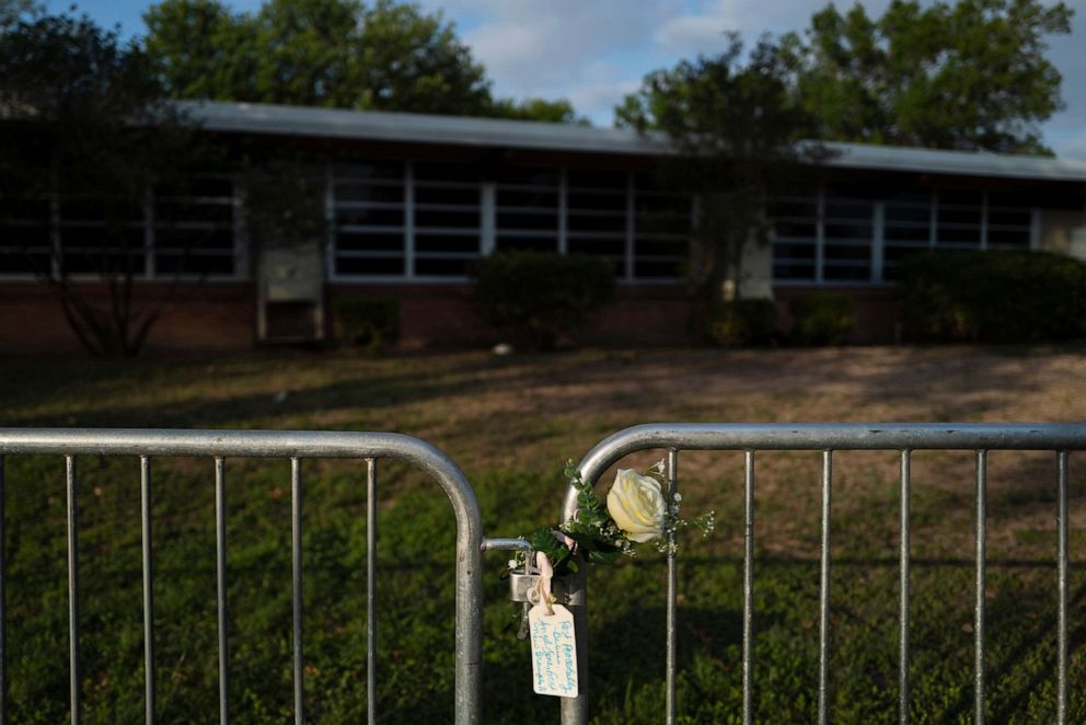 PHOTO: A rose with a message hangs on a barricade at Robb Elementary School in Uvalde, Texas, May 31, 2022, to honor the victims killed in last week's school shooting that killed 19 children and two teachers.